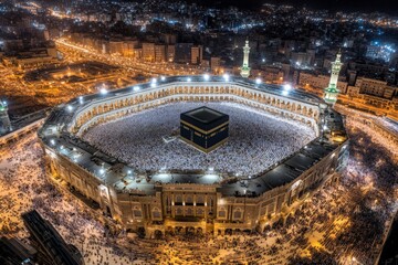 Aerial view of the illuminated Kaaba surrounded by worshippers at night