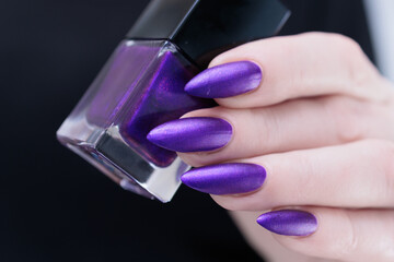 Female hand with long nails and a blue and purple color nail polish
