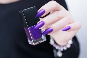 Female hand with long nails and a blue and purple color nail polish