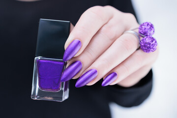 Female hand with long nails and a blue and purple color nail polish