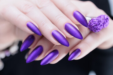 Fototapeta premium Female hand with long nails and a blue and purple color nail polish