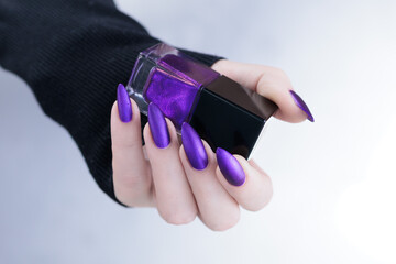 Female hands with long nails and dark purple manicure 