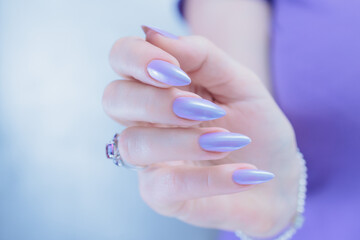 Female hand with long nails and a lilac blue nail polish
