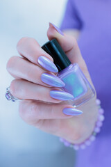 Female hand with long nails and a lilac and blue nail polish
