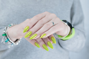 Female hand with long nails and yellow green manicure