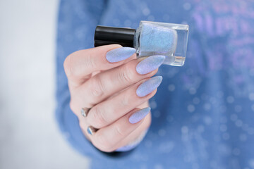 Female hand with long nails and a lilac blue nail polish