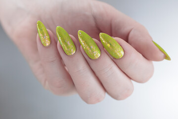 Female hand with long nails and neon yellow green manicure