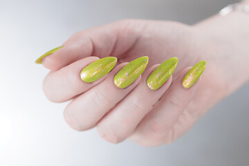 Female hand with long nails and neon yellow green manicure
