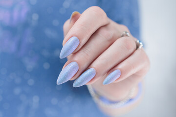 Woman's beautiful hand with long nails and light blue and lilac manicure	