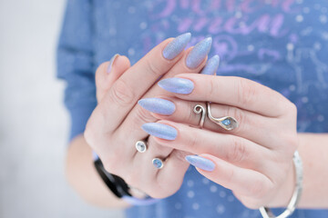 Woman's beautiful hand with long nails and light blue and lilac manicure	