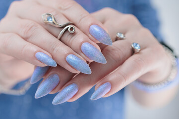 Woman hand with long nails manicure and light lilac and blue nail polish
