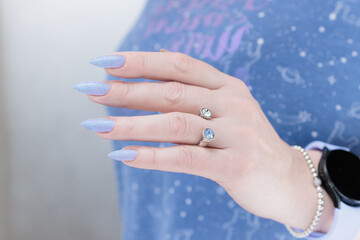Woman's beautiful hand with long nails and light blue and lilac manicure	