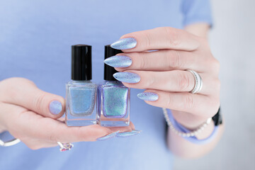 Woman hand with long nails manicure and light lilac and blue nail polish