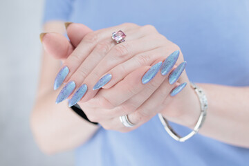 Woman hand with long nails manicure and light lilac and blue nail polish