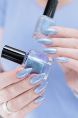 Woman hand with long nails manicure and light lilac and blue nail polish