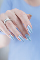 Woman hand with long nails manicure and light lilac and blue nail polish
