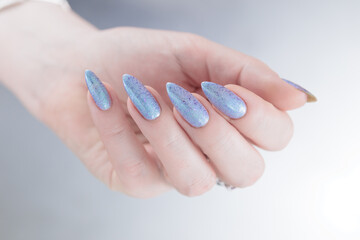 Womans hands with long nails light gray blue manicure	
