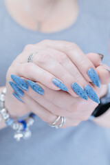 Womans hands with long nails light gray blue manicure	