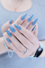 Womans hands with long nails light gray blue manicure	