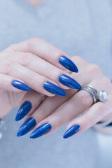 Woman's beautiful hand with long nails and blue manicure