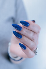 Woman's beautiful hand with long nails and blue manicure