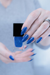 Woman's beautiful hand with long nails and blue manicure