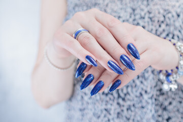 Woman's beautiful hand with long nails and blue manicure