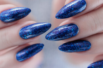 Woman's beautiful hand with long nails and blue manicure