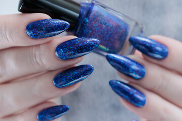 Woman's beautiful hand with long nails and blue manicure