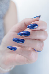 Woman's beautiful hand with long nails and blue manicure