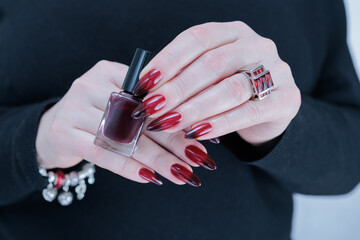 Female hands with long nails and black and red nail polish
