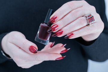 Female hands with long nails and black and red nail polish
