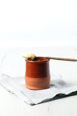 Isolated still life of homemade custard on white wooden board