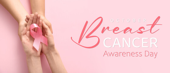 Women holding pink ribbon on color background, closeup. Breast cancer awareness concept