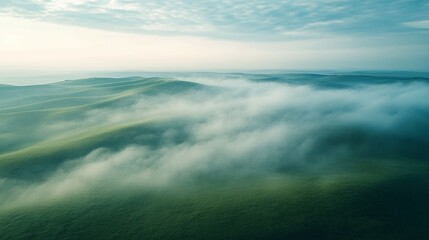 Obraz premium Aerial View of Rolling Green Hills Cloaked in Mist