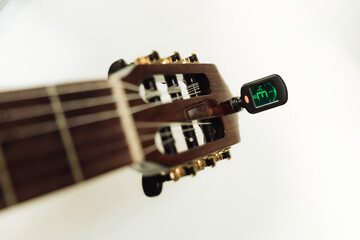 tuning an acoustic guitar using a tuner. close-up. isolated on white background
