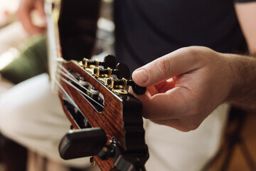 Person tuning a guitar over white background