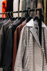 Autumnal stylish leather jackets hanging in a row on hangers in a fashion luxury boutique
