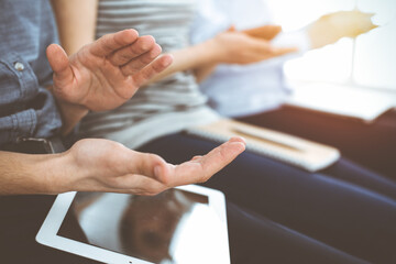 Business people clapping at meeting or conference, close-up of hands. Group of unknown businessmen and women in sunny office