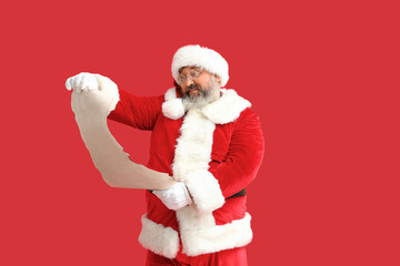 Santa Claus reading letter on red background