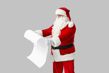 Santa Claus with reading letter on grey background