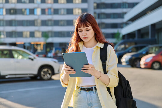 Young female college student using digital tablet outdoor