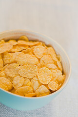 Crispy Corn Flakes in Blue Bowl, with copy space in the back (Selective Focus, Focus one third into the bowl)