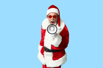 Santa Claus in sunglasses with megaphone screaming on blue background