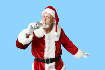 Santa Claus in glasses with microphone singing on blue background