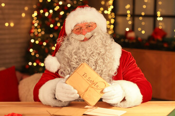 Santa Claus with letters at home on Christmas eve