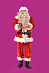 Santa Claus with tasty donuts on purple background