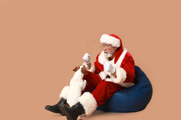 Santa Claus with cute Jack Russell Terrier dog on brown background