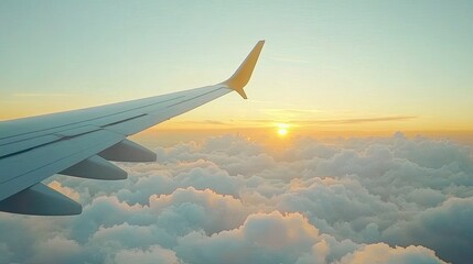 Obraz premium Airplane wing and sunset over fluffy clouds.