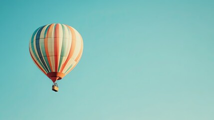 Fototapeta premium A colorful hot air balloon floats in a clear blue sky, with copy space on the right.